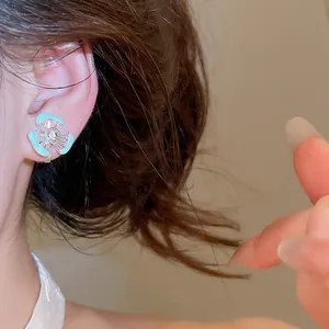 Detailansicht eines hellblauen Emaille-Blumen-Ohrclips mit Zirkonia für Ohren ohne Löcher