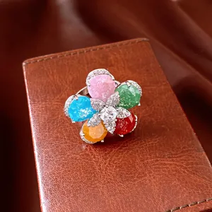 Detailed close-up of a vibrant 18k gold plated flower ring with multi-color stones.