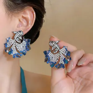 Close-up detail of elegant blue zircon carp earrings featuring sparkling gemstones.