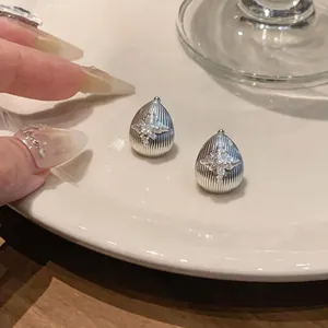 Vue détaillée de boucles d'oreilles en goutte avec un motif de fleur en zircone.
