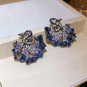 Detailed close-up view of vintage fish-shaped earrings with purple and blue zircon stones