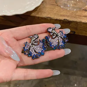 Detailed view of vintage carp fish earrings encrusted with sparkling colorful zircons
