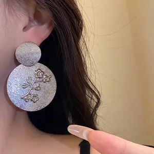 Silver-finish metal pleated round earrings with detailed floral engraving for women