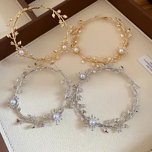 Detailansicht eleganter Reifenohrringe aus Gold und Silber mit Perlenblumenakzenten.