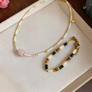 Close-up of ethnic glass beaded necklace and bracelet set on a beige jewelry tray