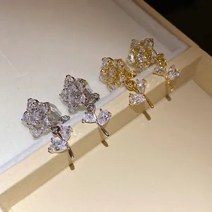 Detailed close-up of 14k gold-plated zircon flower ear clips with sparkling stones