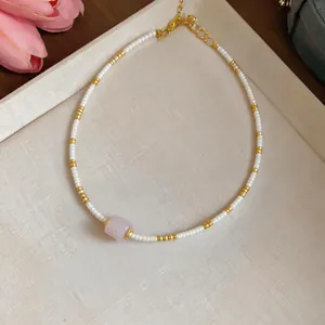 Detailed macro view of an ethnic style beaded necklace featuring an elegant pink stone pendant
