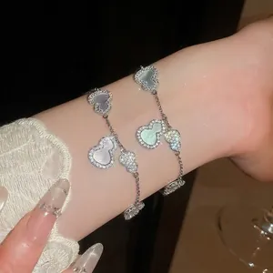 Bracelet élégant avec zircons et nacre en forme de gourde, finition argentée raffinée.