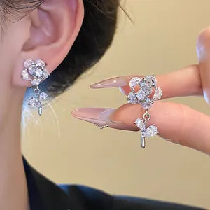 Exquisite detail of silver plated flower earrings featuring shiny zircon stones and leaf drops