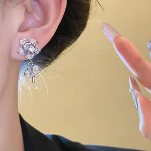 Close-up of elegant zirconia flower ear clip with sparkling teardrop pendant