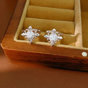 Elegant silver fleur-de-lis cross hoop earrings with clear zircons in a wooden display box