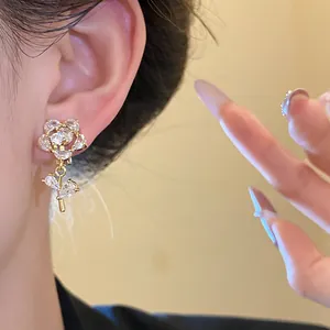 Exquisite close-up of zircon flower ear clip with 14k gold plating on a model's ear