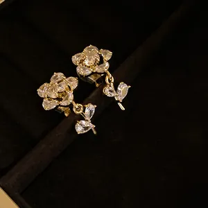 Detailed view of 14k gold plated zircon flower clip-on earrings on black velvet background