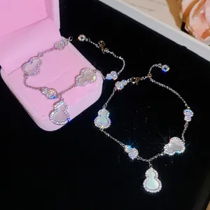 Détail d'un bracelet en argent élégant avec zircon brillant et breloques nacre en gourde.