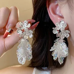 Elegant floral tassel earrings with iridescent leaf pendants and textured silver finish.