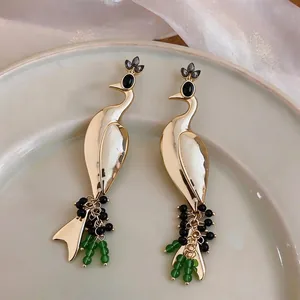 Vintage peacock drop earrings in gold with elegant green and black bead accents