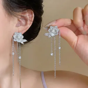 Elegante silberne Rosen-Quastenohrringe mit Zirkonia und Perlen an einem weiblichen Modell