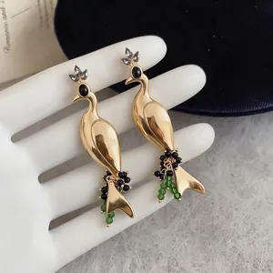 Elegant vintage gold peacock drop earrings adorned with black and green beads