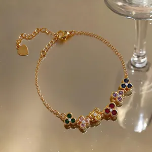 Macro detail of a vintage French-style gold bracelet featuring colorful zircon flowers