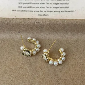 Elegant retro gold-tone hoop earrings with white pearls and a small flower detail