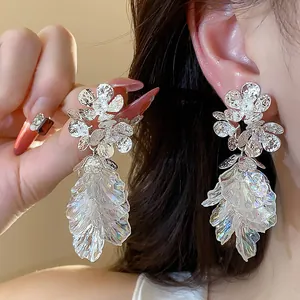 Exquisite detail of 18k gold plated floral stud earrings with shimmering iridescent tassels