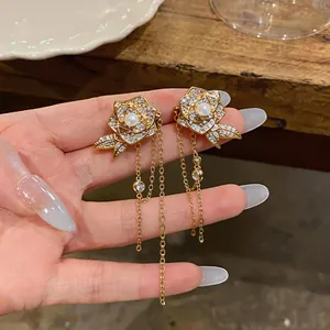 Nahaufnahme von luxuriösen 18K vergoldeten Blumenohrringen mit Zirkonia und Perlen