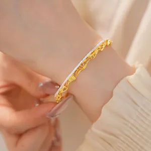 Elegante bracciale rigido dorato vintage francese con motivo traforato in pizzo e cristalli