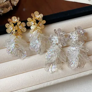 Detail view of 18k gold and silver plated zircon floral earrings with petal tassels.