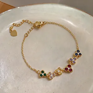 Close-up of a French retro gold bracelet featuring five colorful zircon flower charms.