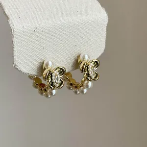 Detailed view of elegant vintage gold floral earrings with pearls and sparkling zircon