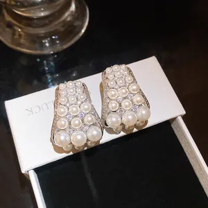 Close-up of French retro stud earrings with elegant pearls and sparkling zircons