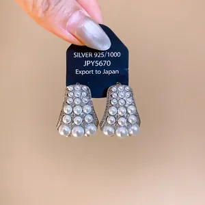 Detail view of French retro pearl earrings with zircon embellishments on display card