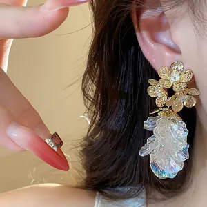 Exquisite 18k gold plated flower stud earring with iridescent tassel detail shown on ear