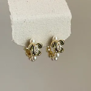 Detailed view of vintage gold flower earrings featuring elegant pearls and zircon stones.