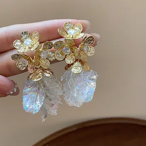 Detailed close-up of elegant 18k gold plated flower stud earrings with iridescent petals