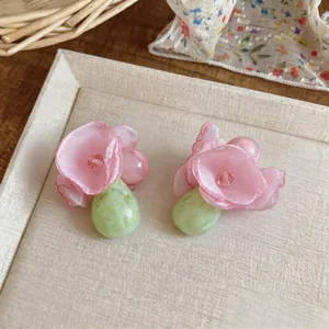 Exquisite Nahaufnahme von Chiffonblumen-Ohrringen mit grünen Harz-Tropfenanhängern