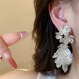 Macro detail of zircon flower tassel earrings with 18k gold plating shown on model