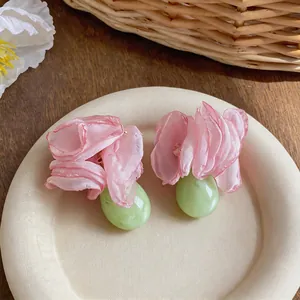 Elegante Ohrringe mit rosa Chiffonblumen und grünen Harztropfen im Detail