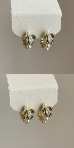 Detailed macro view of vintage gold hoop earrings featuring pearls and zircon flowers