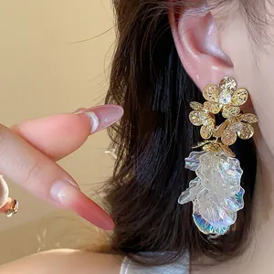 Detailed close-up of 18k gold plated flower stud earrings with iridescent petals