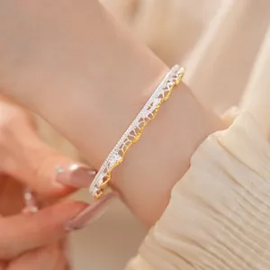 Dettaglio ravvicinato di un bracciale traforato in stile pizzo vintage argento e oro