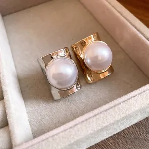 Elegant gold and silver open rings featuring large white pearls in jewelry tray