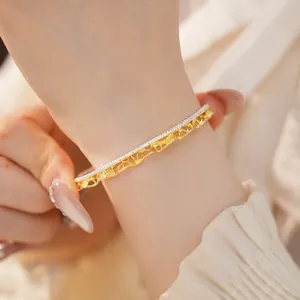 Macro del bracciale traforato in pizzo oro e argento in stile vintage francese al polso