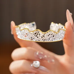 Dettaglio di bracciale rigido traforato stile pizzo vintage francese bicolore