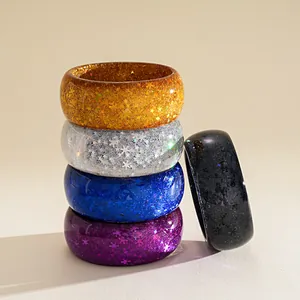 Macro shot of stackable colorful resin bangles with star and snowflake glitter flakes