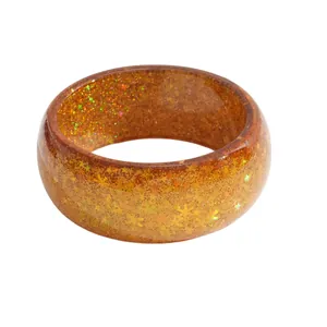 Transparent amber resin bangle bracelet featuring golden star and snowflake glitter