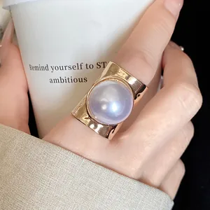 Close-up detail of a elegant large purple pearl ring with a polished gold band finish