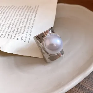 Close-up of silver-tone hammered ring band featuring a large pearl inlay detail