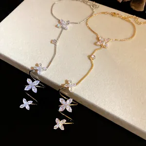 Macro detail showing elegant gold and silver zircon flower slave bracelets on a stand.