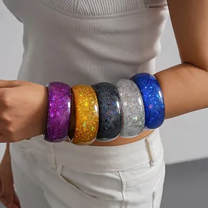 Colorful resin bangles with glitter star and snowflake sequins worn on arm detail view